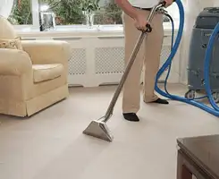 Carpet cleaning professional removing dirt and stains with a hot-water extraction tool in a home, San Jose, CA.