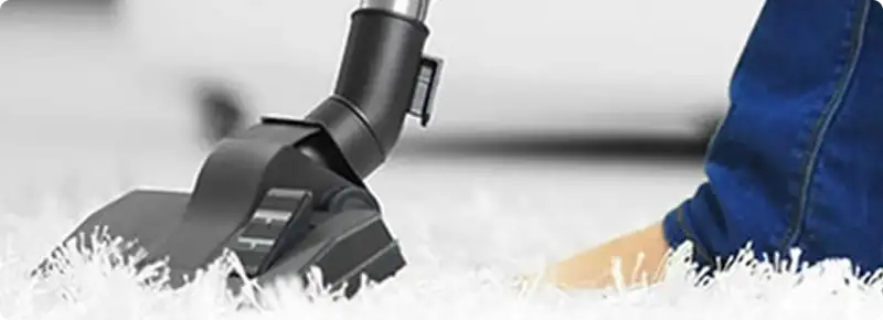 Close-up of a professional vacuuming a white carpet in Cupertino.