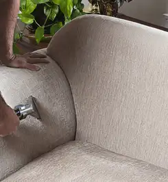 Professional upholstery cleaner deep-cleaning a fabric sofa with a handheld extraction tool and hose San Jose, CA.